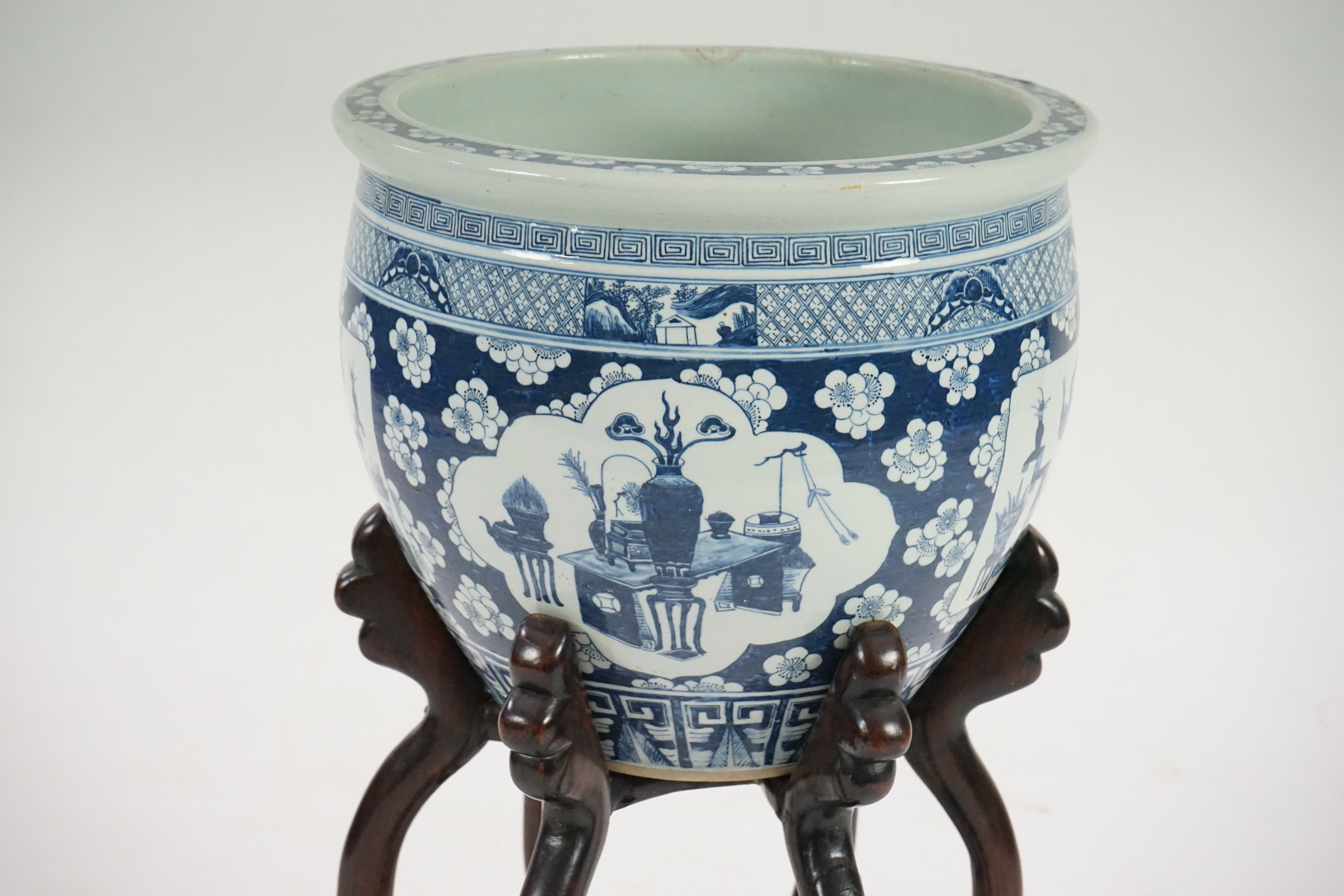 A large Chinese blue and white ‘Hundred Antiques’ jardinere and hongmu stand, late 19th/early 20th century